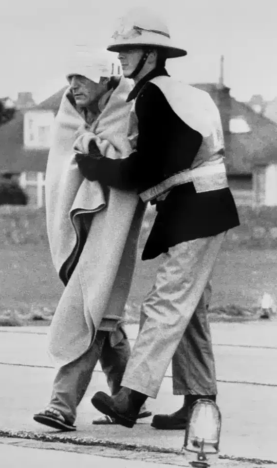 A bandaged survivor (one of 61) is helped after arriving at Aberdeen Royal Infirmary.